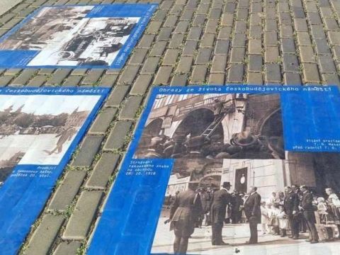 Postery s historickými fotografiami, nalepené na dlažbe histického námestia v Českých Budějoviciach 